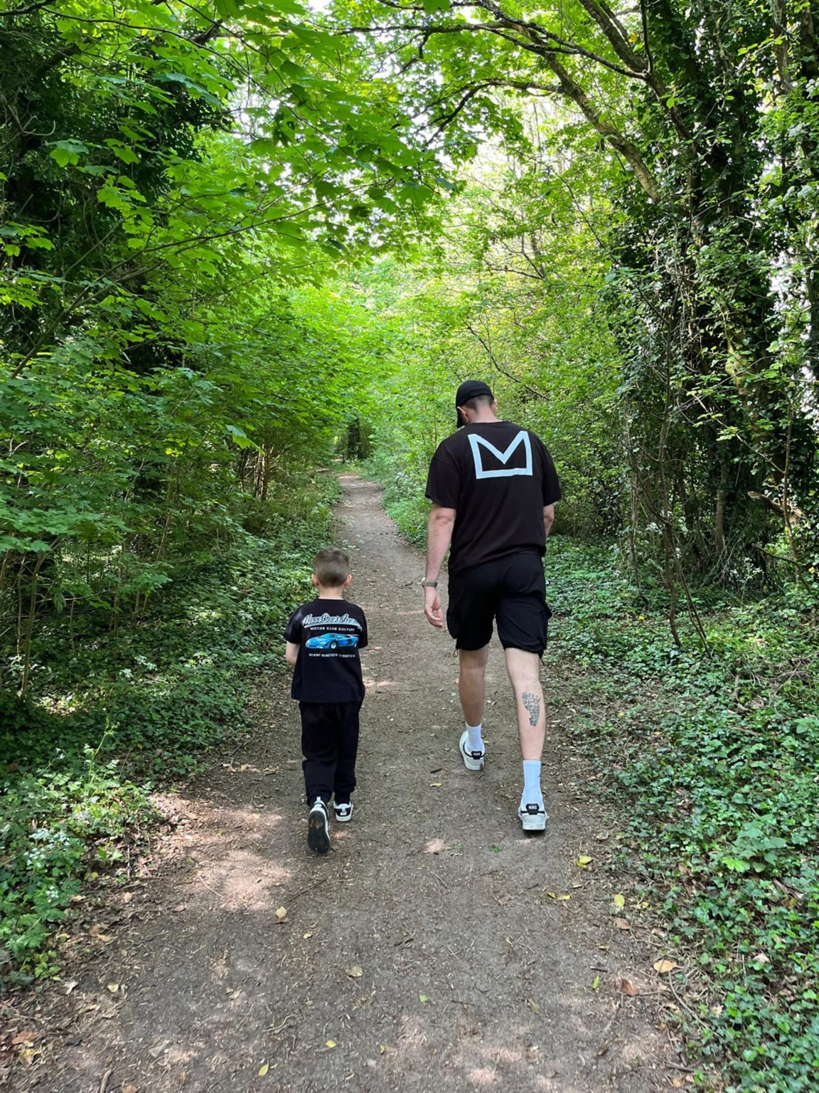 Adult and child walking through woodland in MOVA clothing